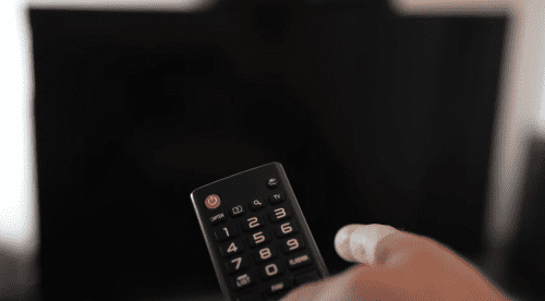 Person Using Remote on TV